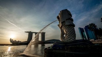 dusk，A wide shot of the Merlion looking at Marina Bay Sands and ArtScience Museum